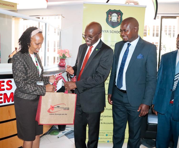 KUCCPS Chief Executive Officer Dr. Agnes Mercy Wahome hands a package to Kenya School of Law (KSL) Director Dr. Henry Mutai after they launched a partnership on February 10, 2025. The partnership is meant to enable applications for Kenya School of Law’s Diploma in Law Course through the KUCCPS portal, during the current course application window. With them are Mr. Gerald Gekombe, KSL’s Paralegal Training Programme Coordinator (3rd left) and Mr. Lawrence Ndirangu, Senior Academic Services Officer at KSL.